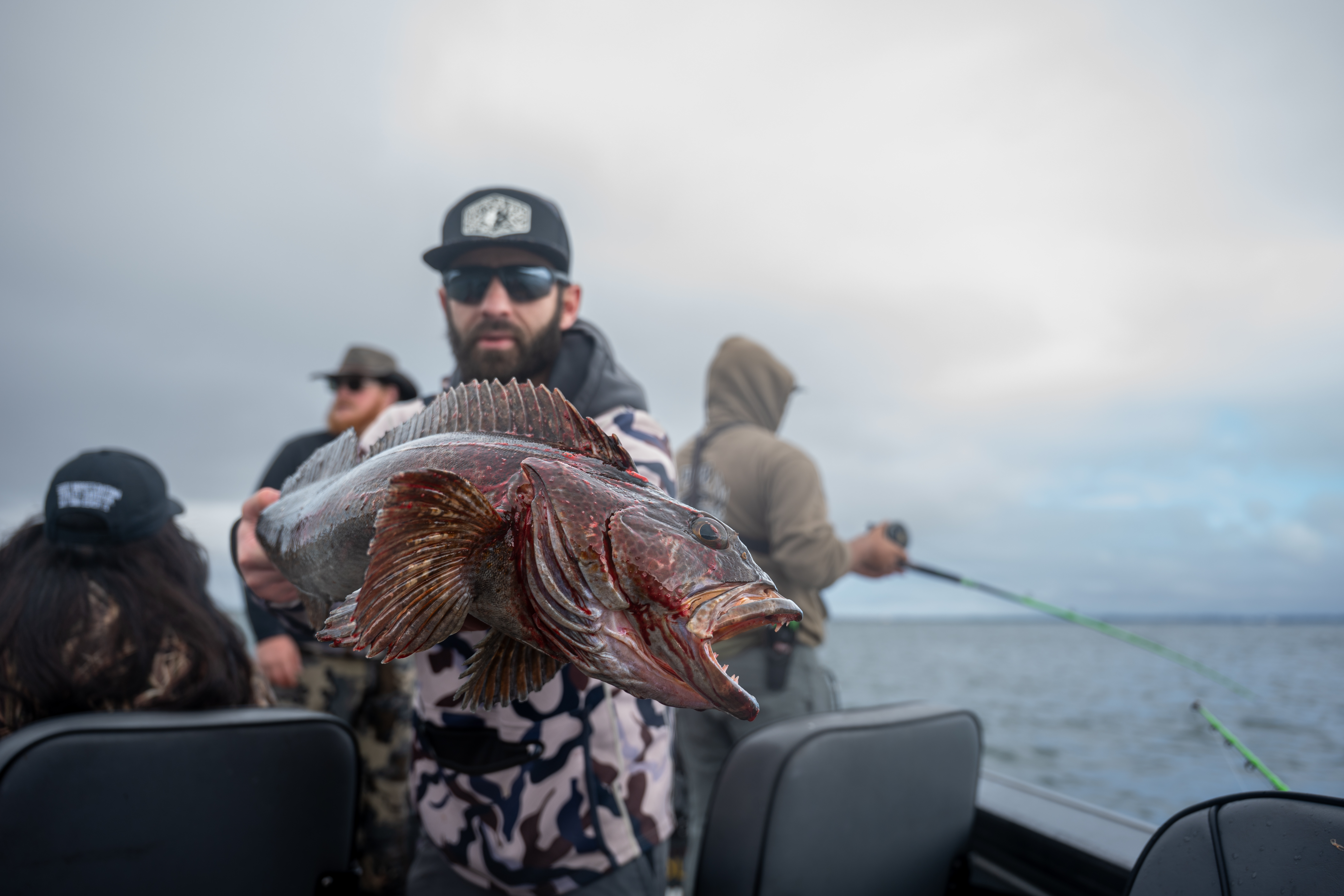 Anglers on a Pacific coast boat with a lingcod