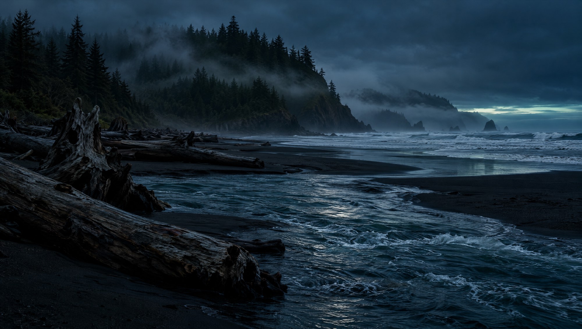 An Olympic coast river mouth at blue hour, driftwood piled on the bank